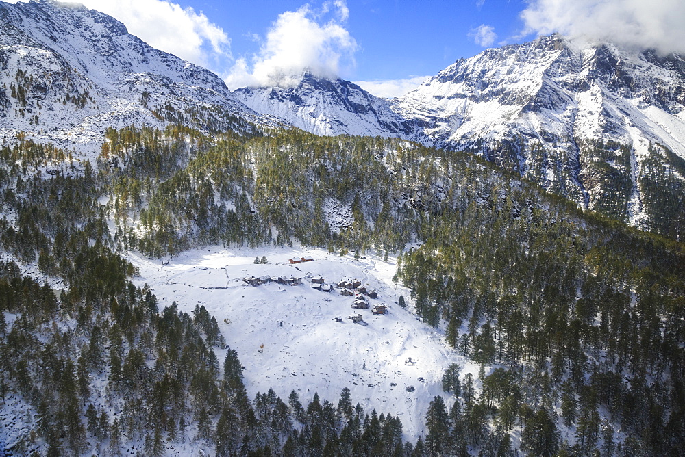 Aerial view of the alpine village of Laguzzola framed by woods and snowy peaks, Spluga Valley, Valtellina, Lombardy, Italy, Europe