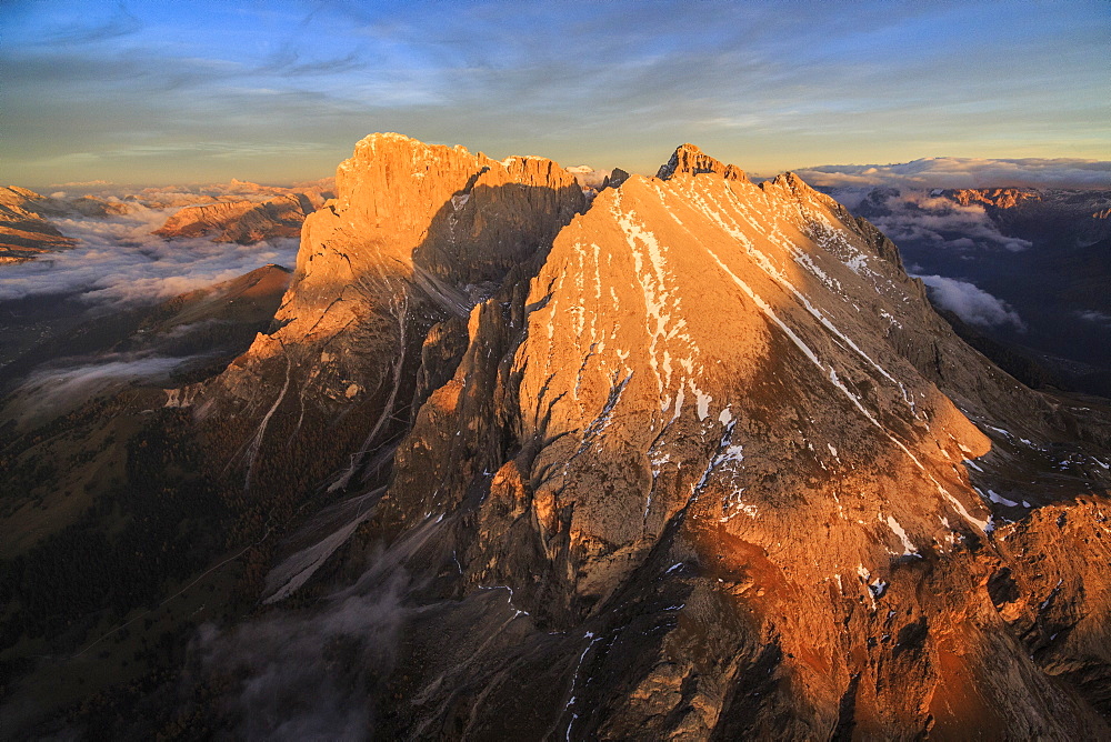 The unmistakable profiles of Sassopiatto (Plattkofel) and Sassolungo (Langkofel) lit by the warm light of the sunset, South Tyrol, Dolomites, Italy, Europe