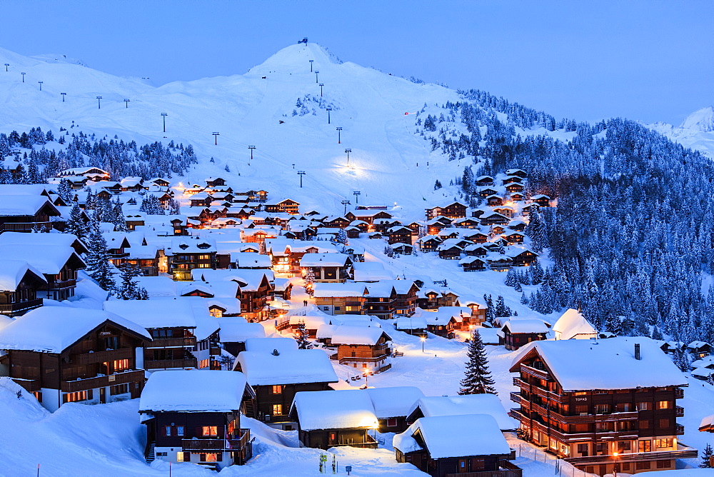 Blue dusk on the snowy alpine village surrounded by ski lifts, Bettmeralp, district of Raron, canton of Valais, Switzerland, Europe