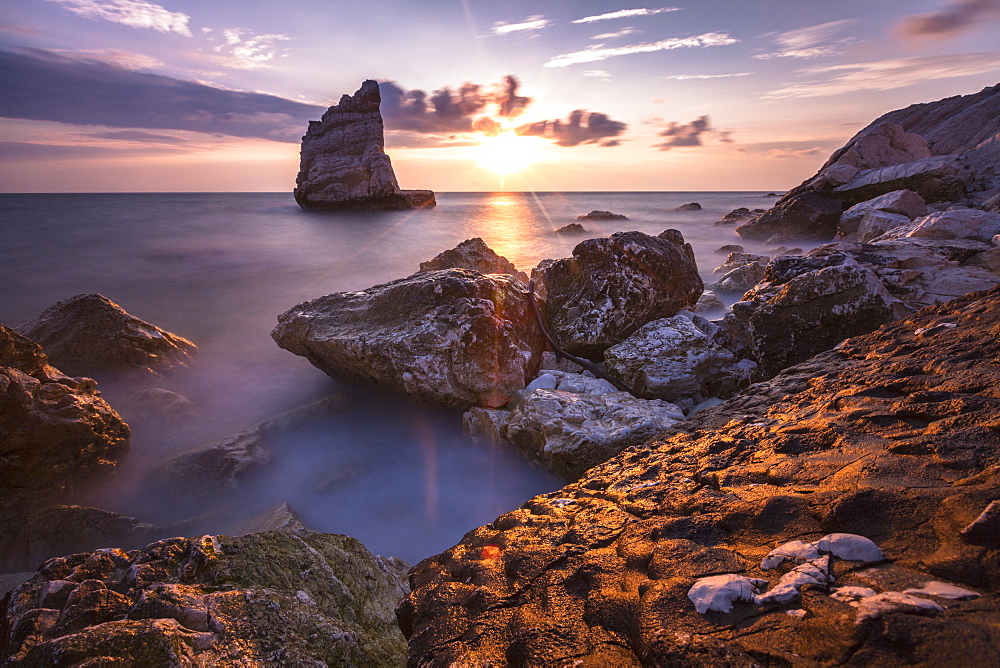 Cliffs and sea framed by the pink sky at sunris, La Vela Beach, Portonovo, Province of Ancona, Conero Riviera, Marche, Italy, Europe