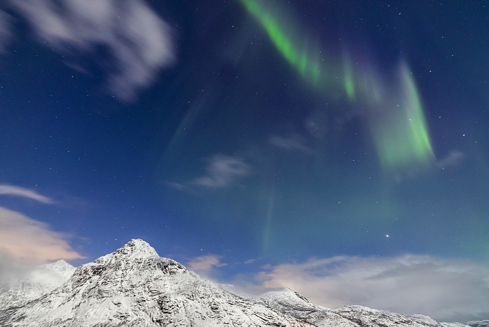 Northern lights (Aurora Borealis) and stars light up the snowy peaks, Vareid, Flakstad, Nordland, Lofoten Islands, Northern Norway, Scandinavia, Europe