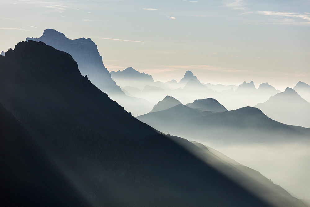 Mist on peaks of Dolomites and Monte Pelmo seen from Cima Belvedere at dawn, Val di Fassa, Trentino-Alto Adige, Italy, Europe