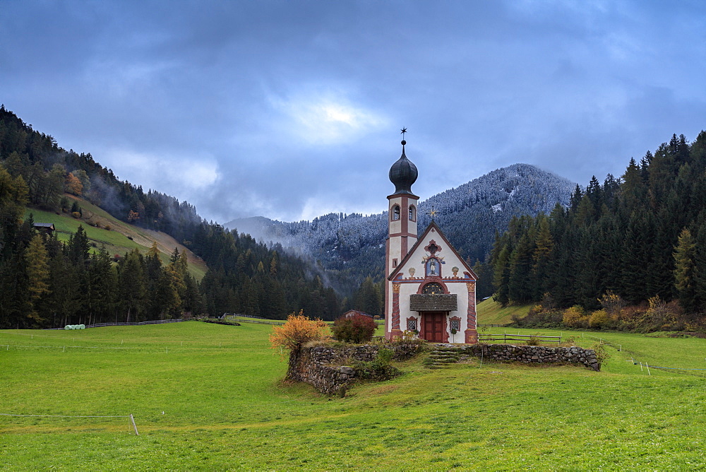 Clouds on Church of Ranui surrounded by meadows and woods in the fall, St. Magdalena, Funes Valley, South Tyrol, Dolomites, Italy, Europe