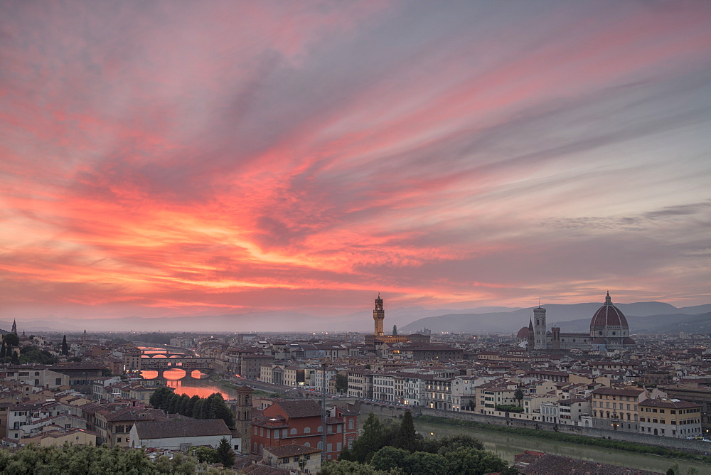 Pink clouds at sunset frame the city of Florence crossed by Arno River seen from Piazzale Michelangelo, Florence, Tuscany, Italy, Europe