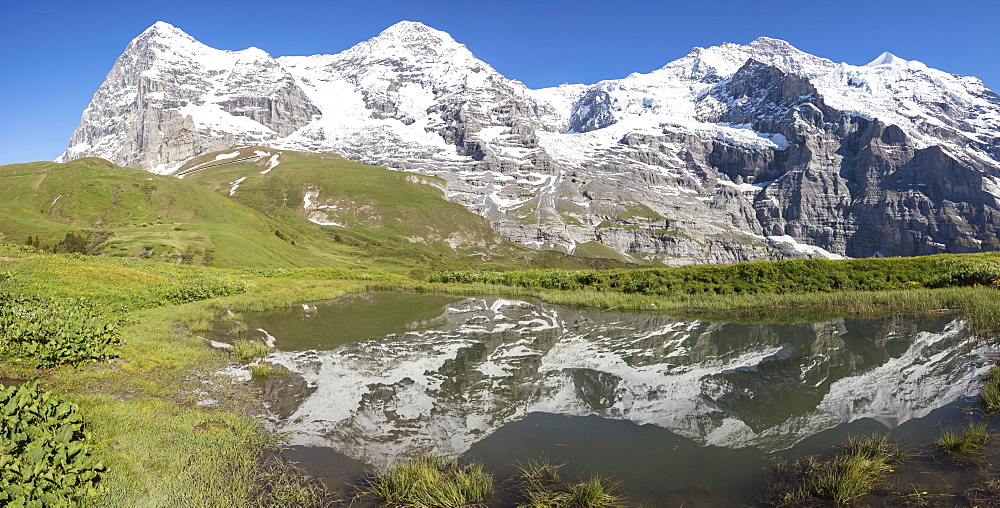 Panorama of snowy peaks reflected in the alpine lake, Wengernalp, Wengen, Bernese Oberland, Canton of Bern, Switzerland, Europe