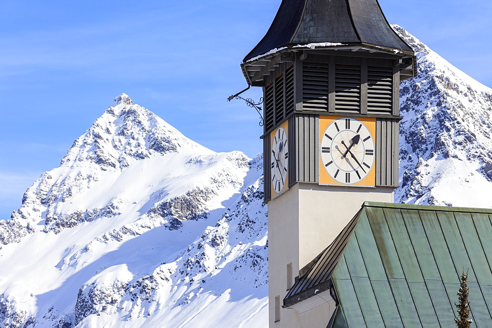 The typical alpine bell tower frames the snowy peaks, Langwies, district of Plessur, Canton of Graubunden, Swiss Alps, Switzerland, Europe