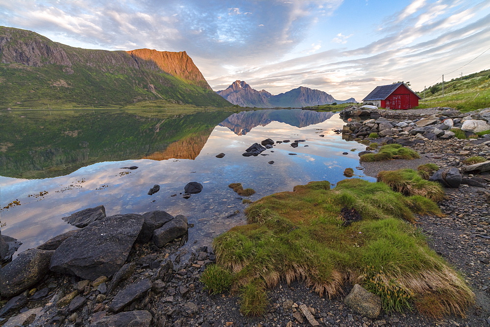 Pink clouds and peaks are reflected in the clear sea at night time, Vengeren, Vagspollen, Lofoten Islands, Norway, Scandinavia, Europe