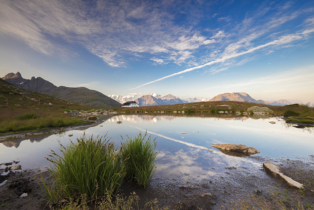 The clear sky is reflected in the blue alpine lake, Muottas Muragl, Samedan, Canton of Graubunden, Engadine, Switzerland, Europe