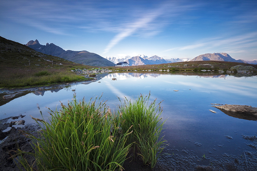 The clear sky is reflected in the blue alpine lake, Muottas Muragl, Samedan, Canton of Graubunden, Engadine, Switzerland, Europe