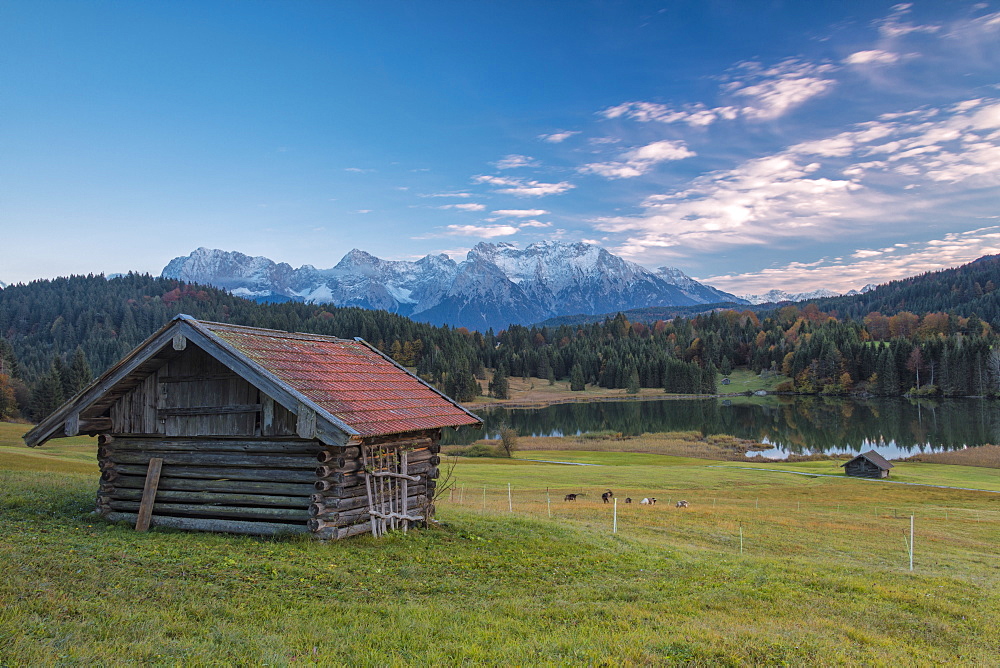 Wooden hut frames the alpine lake surrounded by the Alps, Geroldsee, Krun, Garmisch Partenkirchen, Upper Bavaria, Germany, Europe