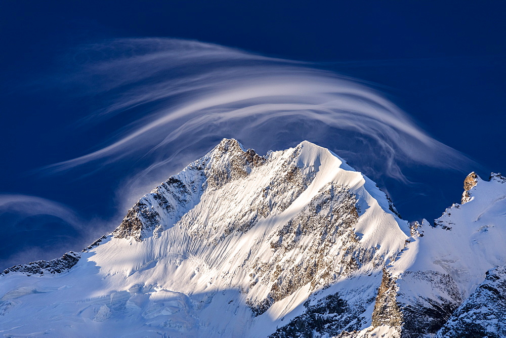 White cloud at dawn lights up Piz Bernina and Biancograt, Engadine, Canton of Graubunden, Engadine, Switzerland, Europe