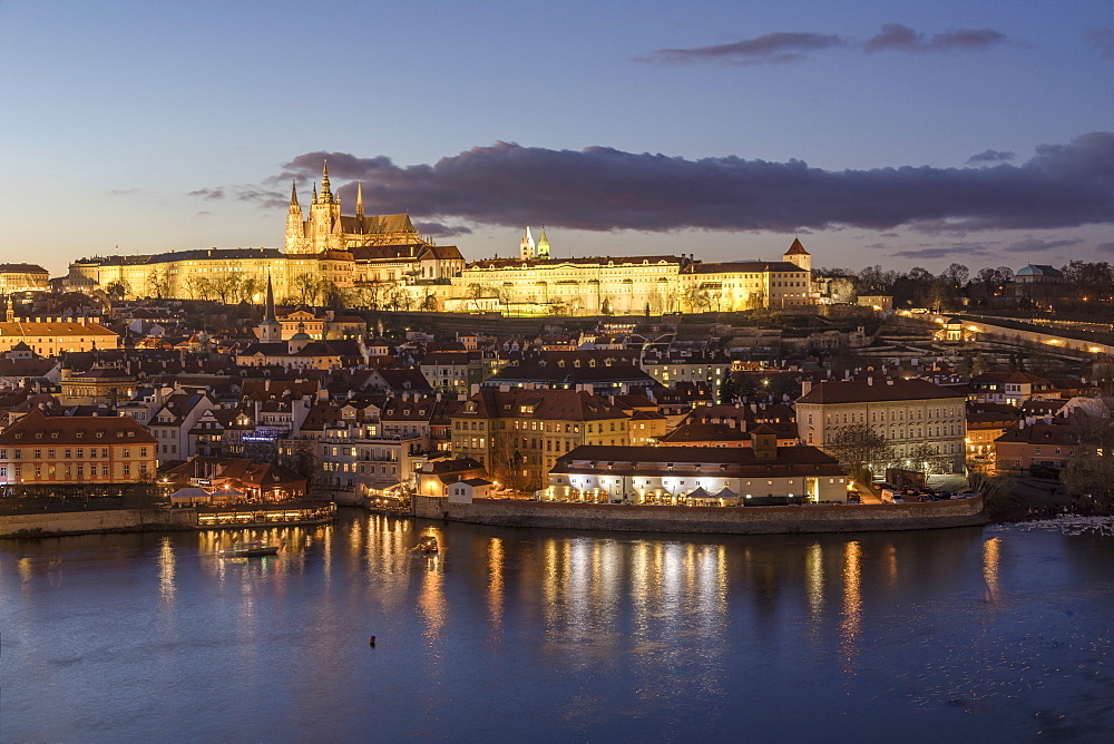 View of the Vltava River framed by historical buildings at dusk, Prague, Czech Republic, Europe