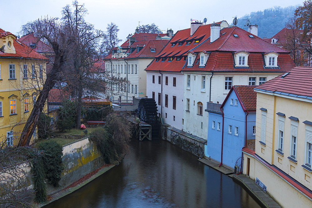 Typical houses on water canal frame the old mill of Certovka, Lesser Quarter, Prague, Czech Republic, Europe