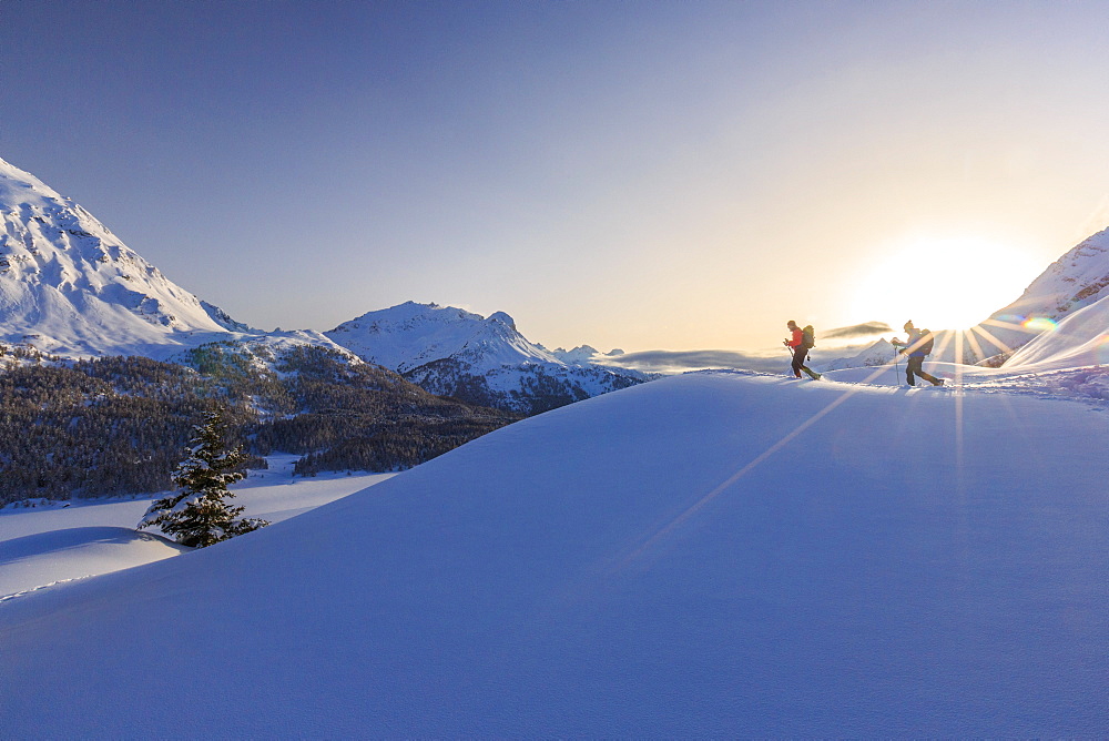 Hikers venturing over the frozen lakes of the Engadine where you can enjoy an exceptional view, Graubunden, Swiss Alps, Switzerland, Europe