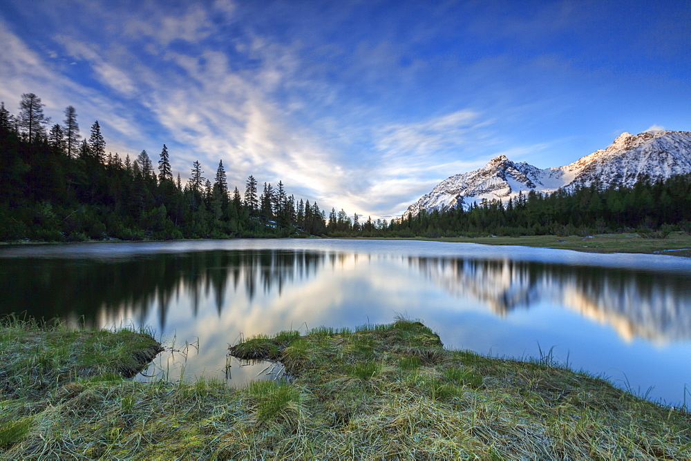 Sunrise frames the snowy peaks reflected in Lake Entova, Malenco Valley, Province of Sondrio, Valtellina, Lombardy, Italy, Europe