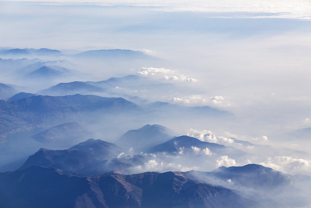 Aerial view of the profile of the mountain peaks surrounded by mist, Orobie Alps, Lombardy, Italy, Europe