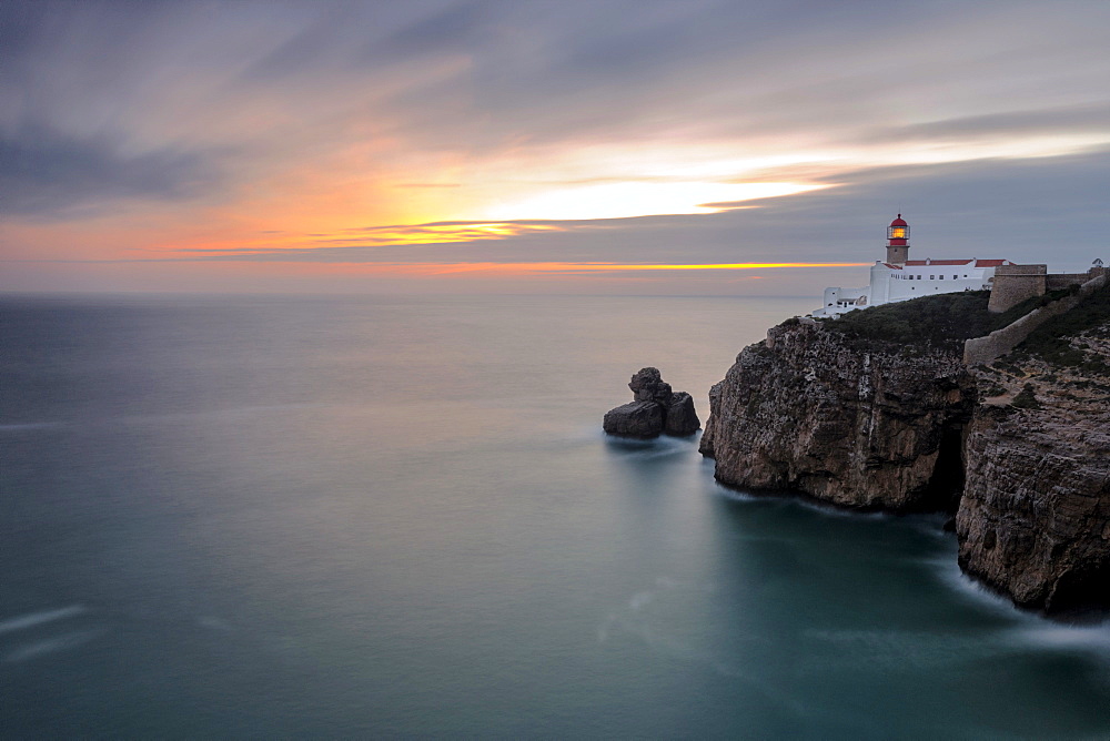 Dusk lights up the lighthouse overlooking the Atlantic Ocean, Cabo De Sao Vicente, Sagres, Algarve, Portugal, Europe