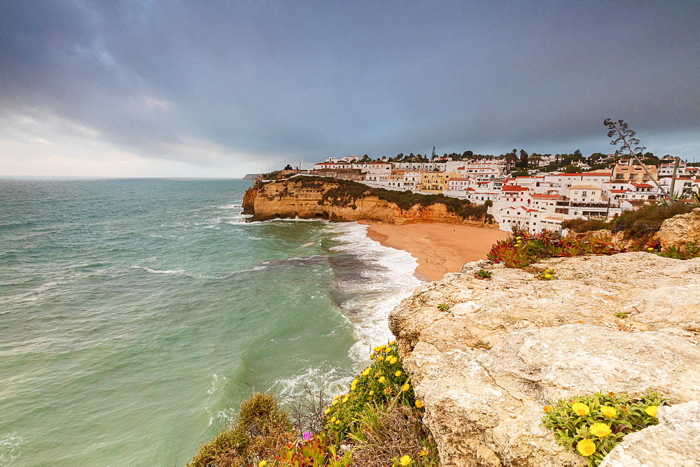 Clouds on Carvoeiro village surrounded by sandy beach and turquoise sea, Lagoa Municipality, Algarve, Portugal, Europe