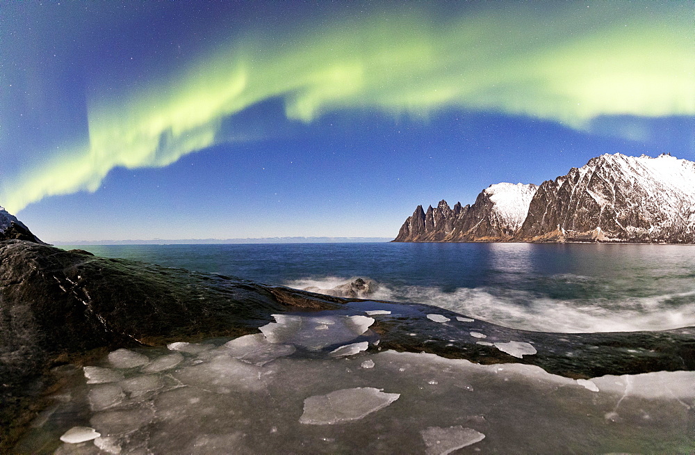 Panorama of frozen sea and rocky peaks illuminated by the Northern Lights (aurora borealis), Tungeneset, Senja, Troms, Norway, Scandinavia, Europe