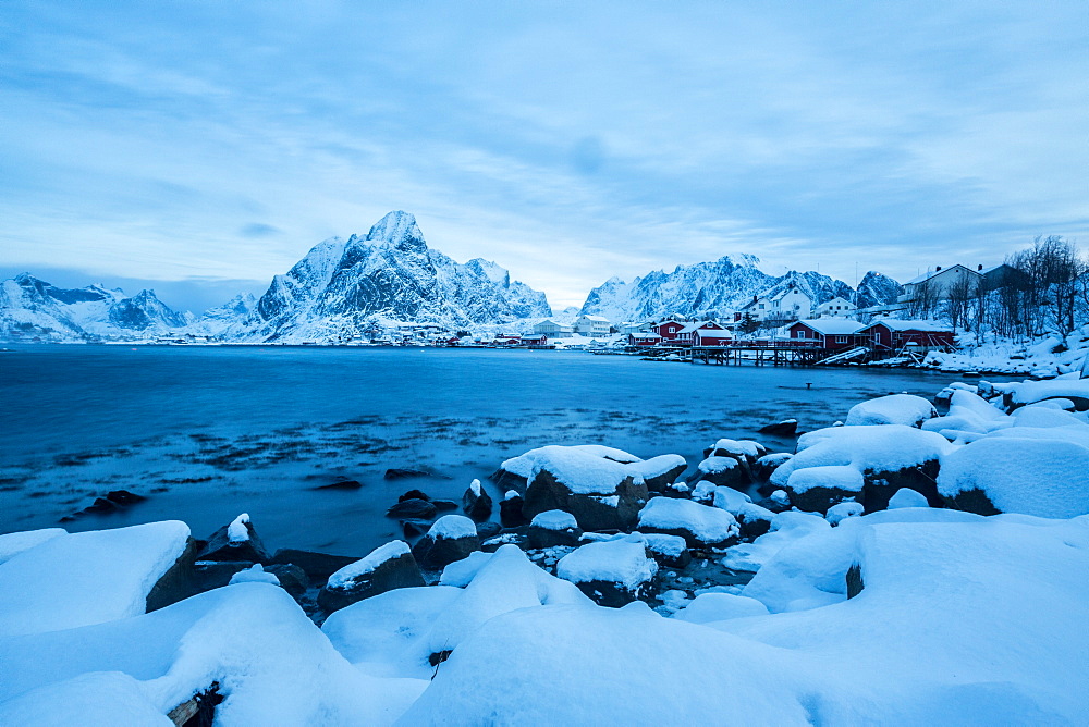 Blue hour in the bay of Reine, where for many months of the year the snow and cold force the residents to remain in their homes, Reine, Lofoten Islands, Arctic, Norway, Scandinavia, Europe