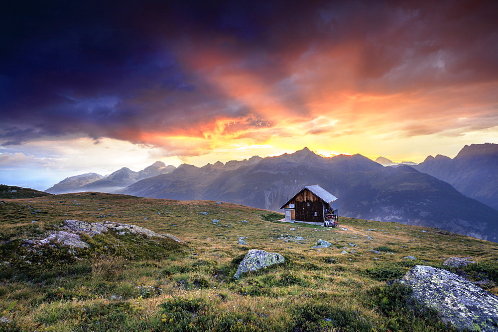 Wooden hut under fiery sky and clouds at sunset, Muottas Muragl, St. Moritz, Canton of Graubunden, Engadine, Switzerland, Europe