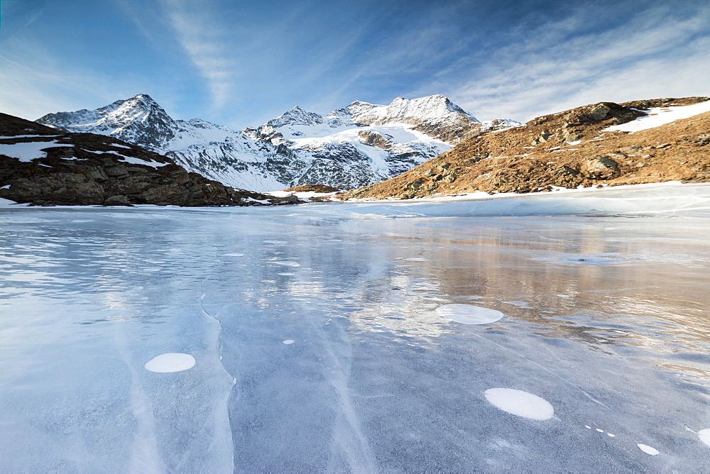 Blue sky on the frozen Lej Nair surrounded by snowy peaks, Bernina Pass, Canton of Graubunden, Engadine, Switzerland, Europe