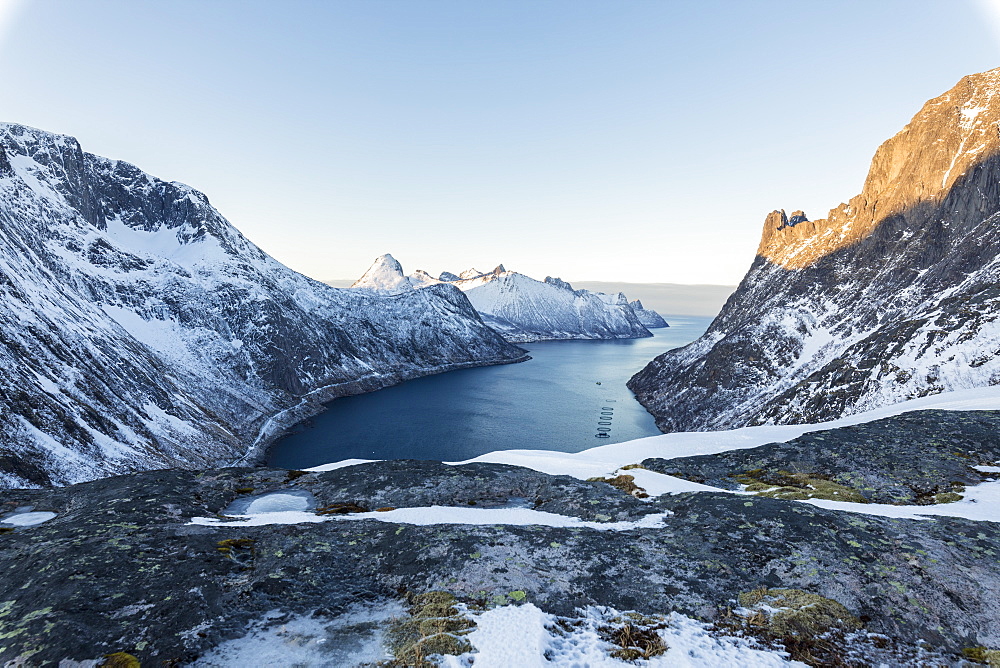 Top view of snowy peaks and frozen sea of the Ornfjorden surrounding the village of Fjordgard, Senja, Troms, Norway, Scandinavia, Europe