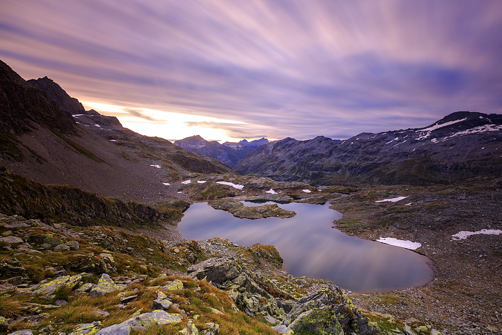 Fiery sky at dawn reflected in Lai Ghiacciato framed by peaks, Val Ursaregls, Chiavenna Valley, Valtellina, Lombardy, Italy, Europe