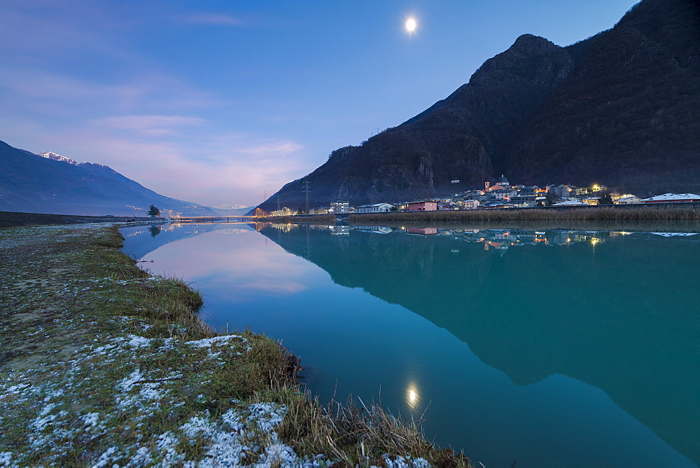 Last light of sunset on Adda River and the village of Sirta Forcola, province of Sondrio, Valtellina, Lombardy, Italy, Europe