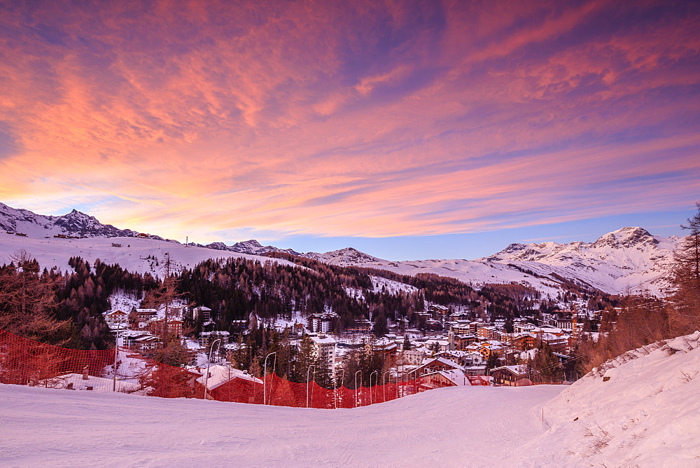 Pink clouds at sunset on the alpine village of Madesimo and the snowy ski slopes, Spluga Valley, Valtellina, Lombardy, Italy, Europe