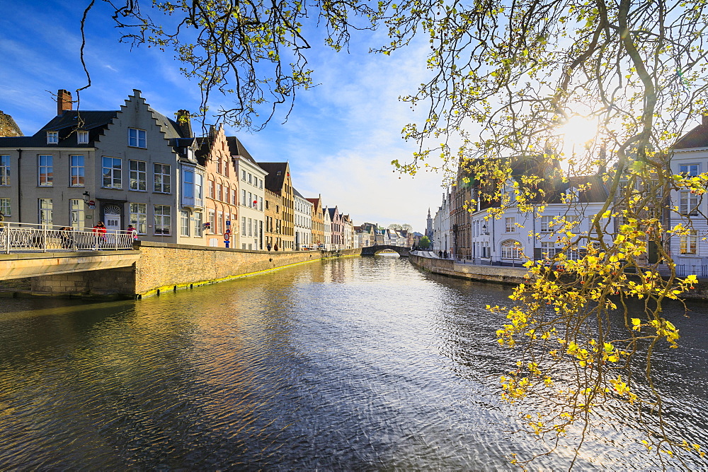 Spring sun on the medieval buildings of the city centre framed by bridges and typical canals, Bruges, West Flanders, Belgium, Europe