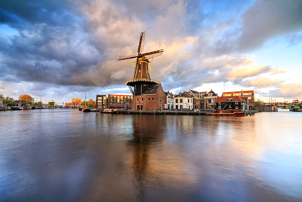 Pink clouds at sunset on the Windmill De Adriaan reflected in the River Spaarne, Haarlem, North Holland, The Netherlands, Europe