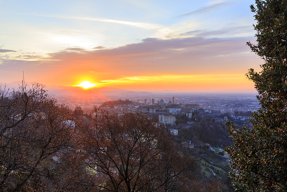 View of the medieval old town called Citta Alta (Upper City) on hilltop framed by the fiery orange sky at dawn, Bergamo, Lombardy, Italy, Europe