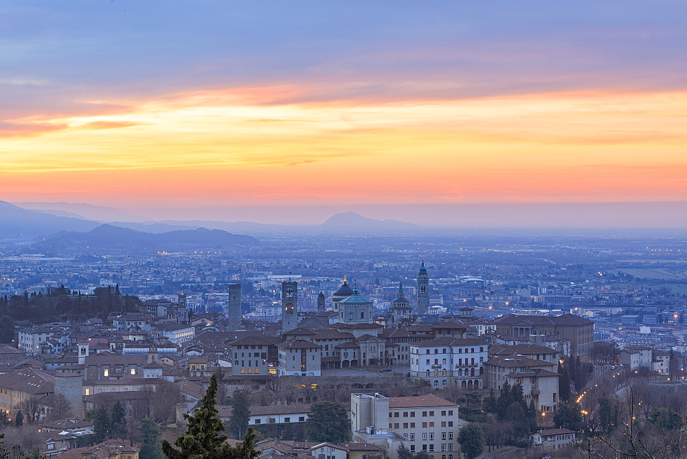 View of the medieval old town called Citta Alta (Upper City) on hilltop framed by the fiery orange sky at dawn, Bergamo, Lombardy, Italy, Europe