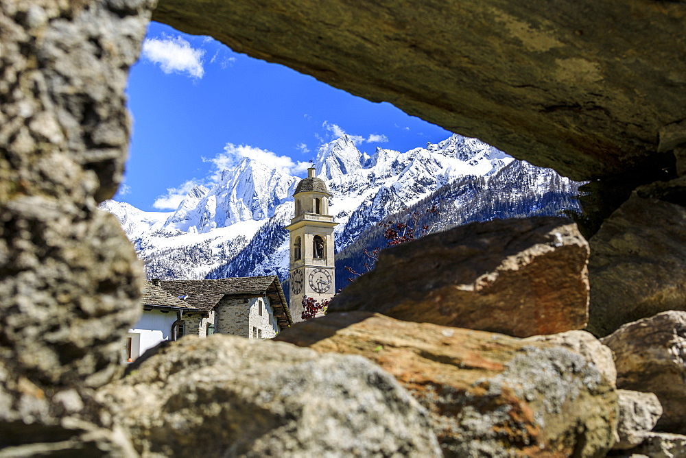 Bell tower and snowy peaks seen from stone arch, Soglio, Maloja, Bregaglia Valley, Engadine, canton of Graubunden, Switzerland Europe