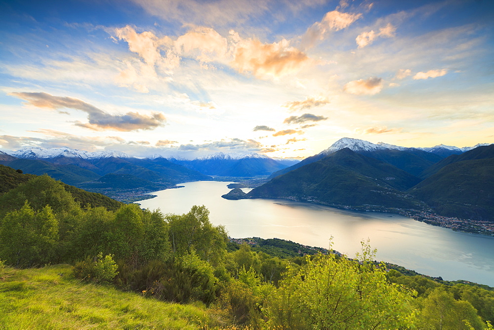 Lake Como surrounded by green meadows framed by pink sky at dawn, Cremia, San Domenico, Lombardy, Italian Lakes, Italy, Europe