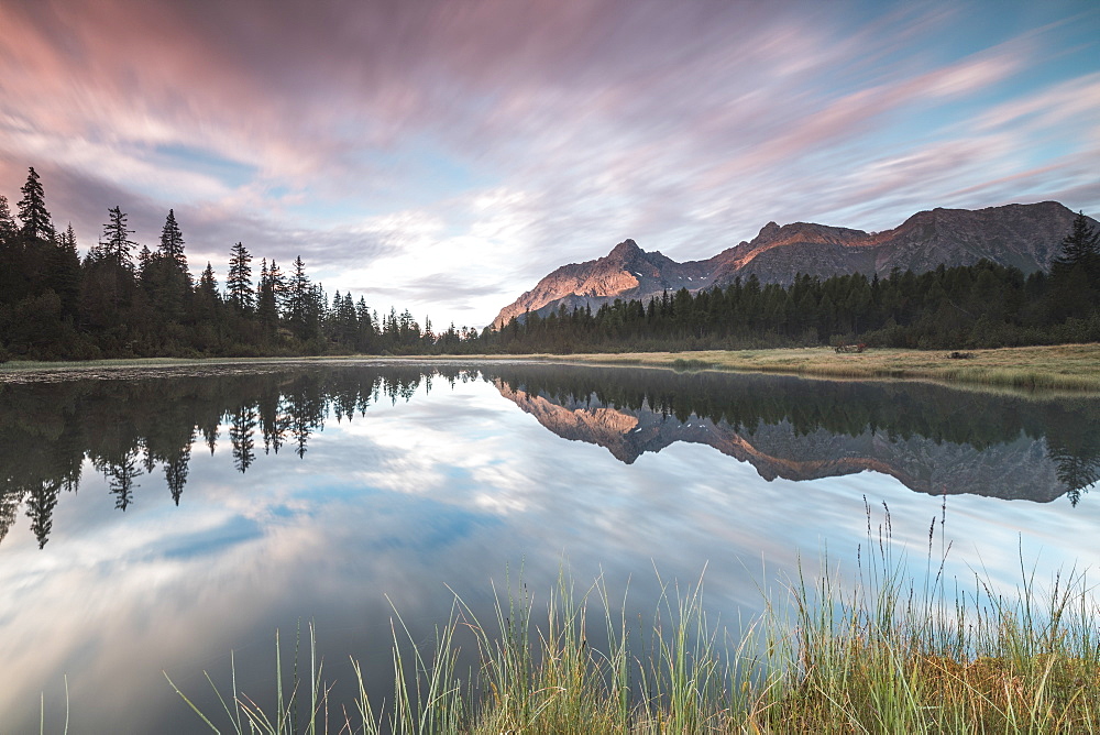 Clouds reflected in Lake Entova at dawn, Entova Alp, Malenco Valley, Sondrio province, Valtellina, Lombardy, Italy, Europe