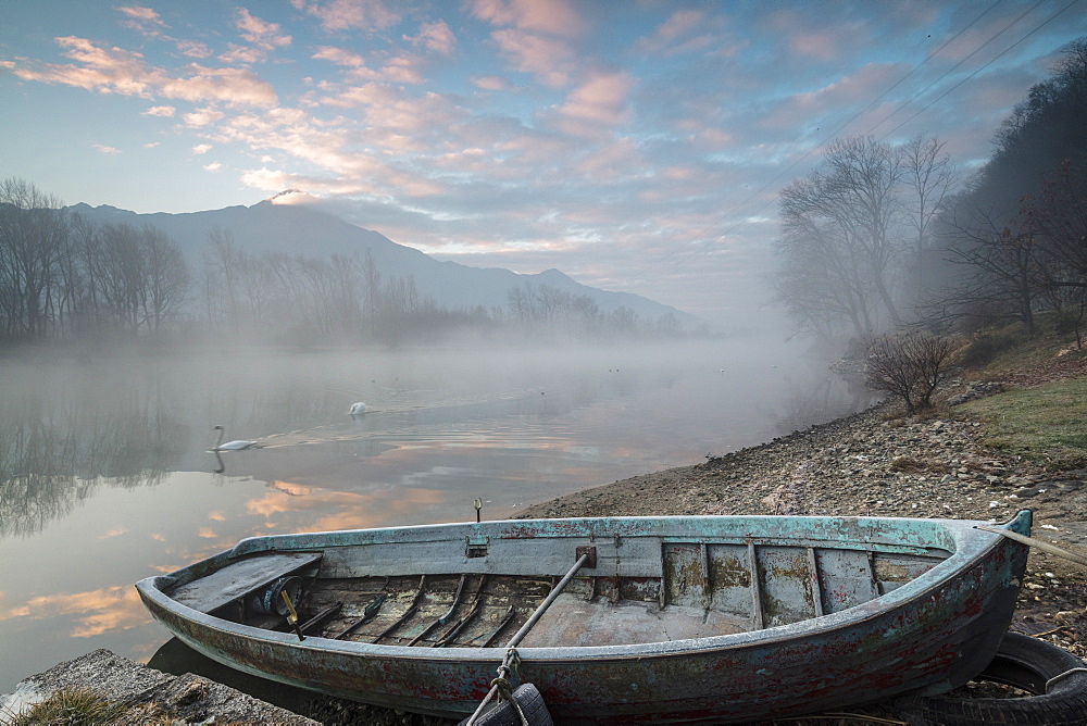 Wood boat on the shore of River Mera at sunrise, Sorico, Como province, Lower Valtellina, Lombardy, Italy, Europe