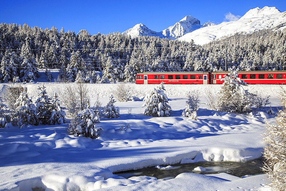 The Bernina Express in a snow-capped Engadine, Switzerland, Europe