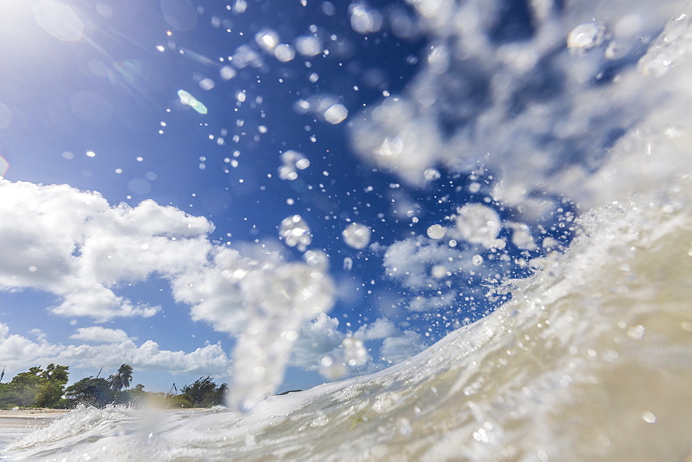 A wave of the Caribbean Sea breaks in front of Fort James at the entrance to the harbor of St.John's, Antigua, Leeward Islands, West Indies, Caribbean, Central America