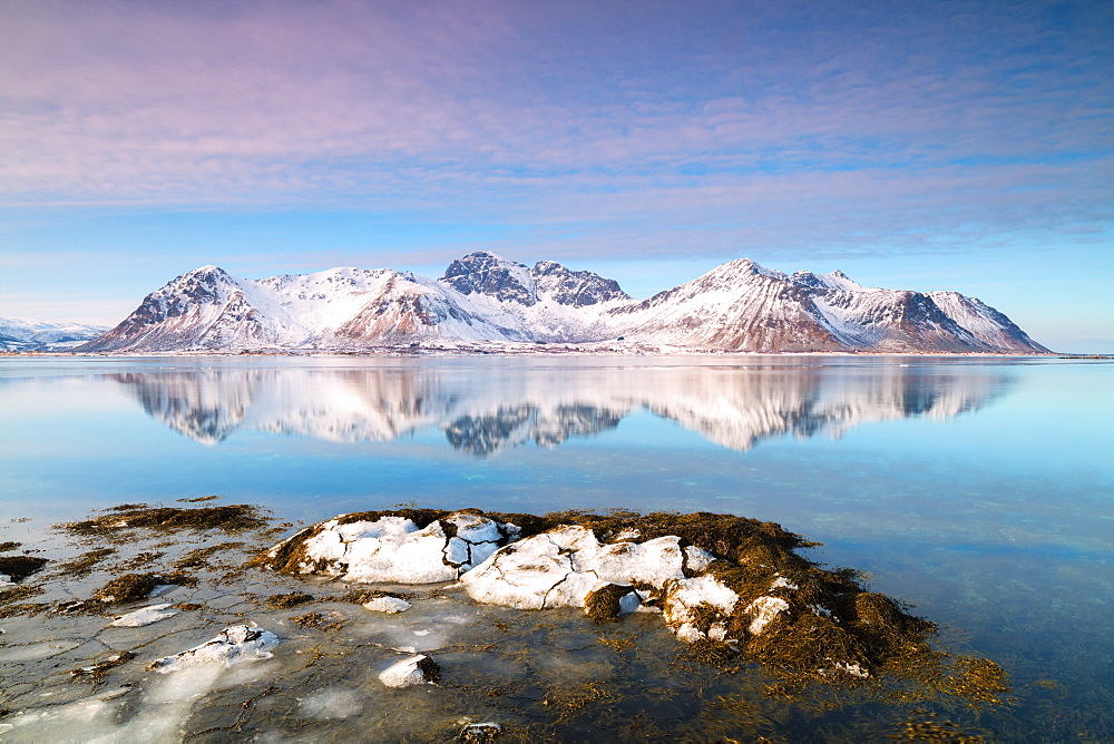 Snowy peaks reflected in the clear sea, Grundstad, Lofoten Islands, Nordland, Norway, Europe