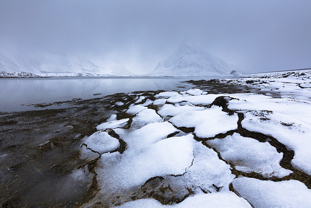 Mist on the snowy peak of Volanstinden, Fredvang, Lofoten Islands, Nordland, Norway, Europe