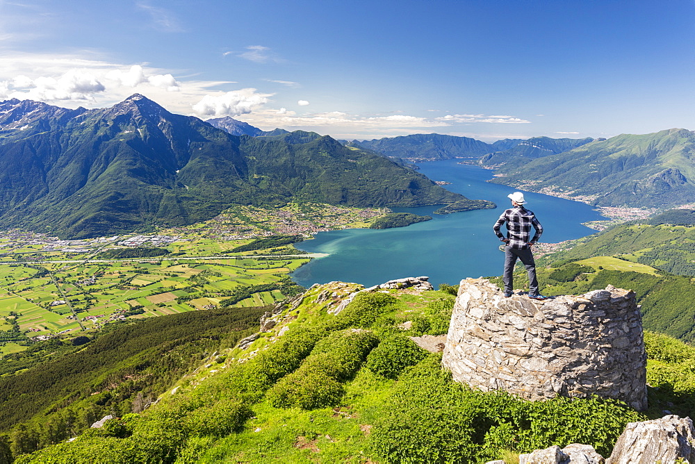 Hiker on top of Monte Berlinghera looks towards Colico and Monte Legnone, Sondrio province, Lombardy, Italy, Europe