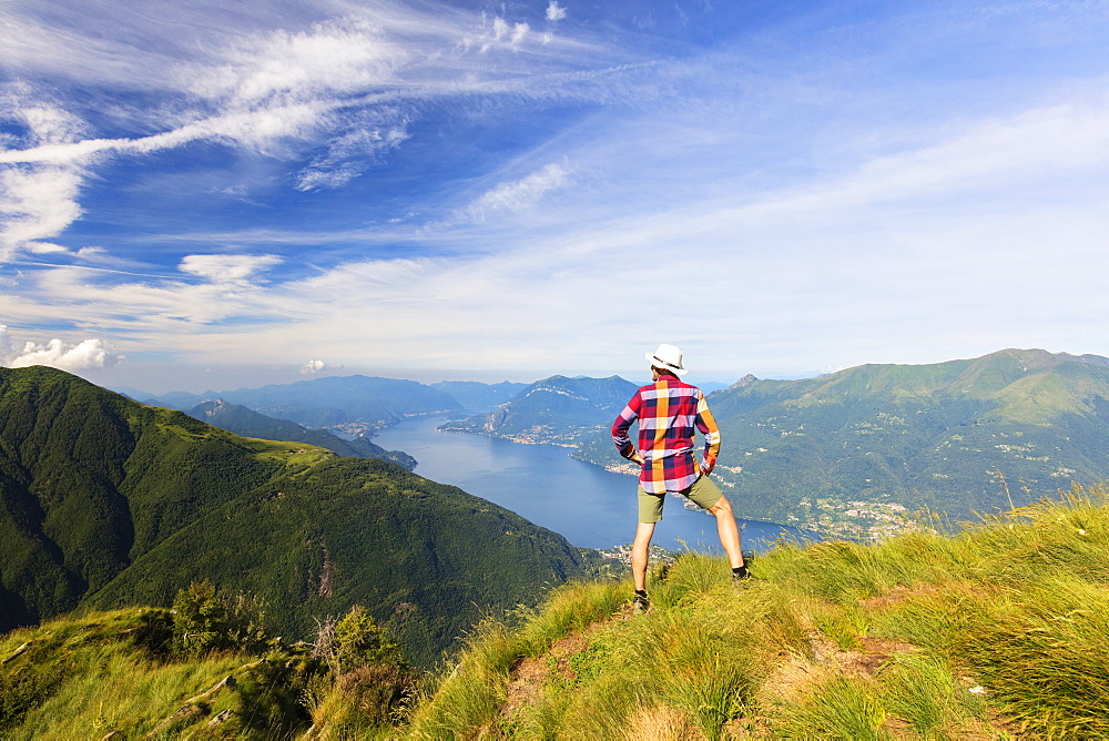 Hiker on Monte Legnoncino admires Lake Como, Lecco province, Lombardy, Italy, Europe