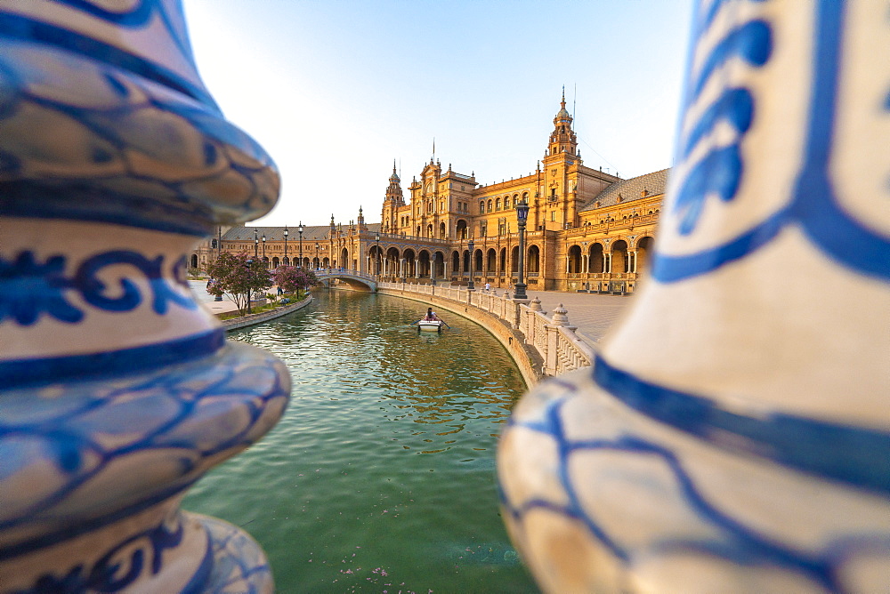 Rowing boat along the canal seen from the ceramic decorated pillars of balustrade, Plaza de Espana, Seville, Andalusia, Spain, Europe