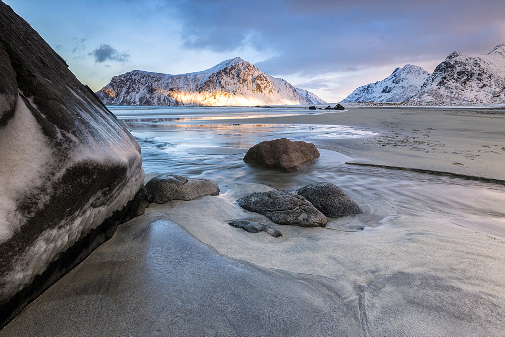 Sunset on the surreal Skagsanden beach surrounded by snow covered mountains, Flakstad, Lofoten Islands, Arctic, Norway, Scandinavia, Europe