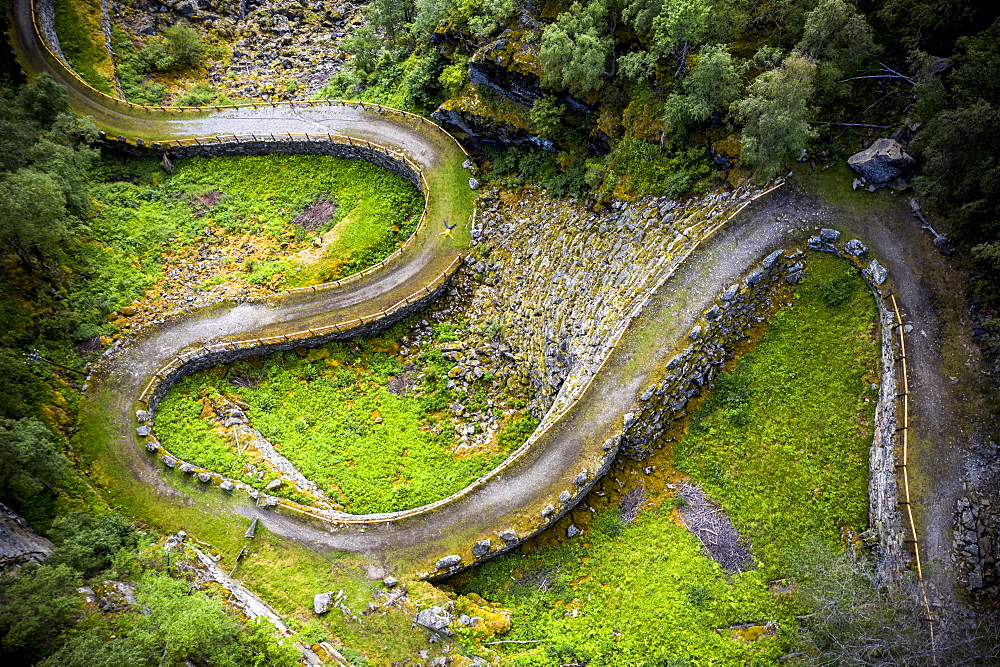 Aerial view of man lying down along the bends of historic Vindhellavegen road, Borgund, Laerdal, Sogn og Fjordane county, Norway, Scandinavia, Europe