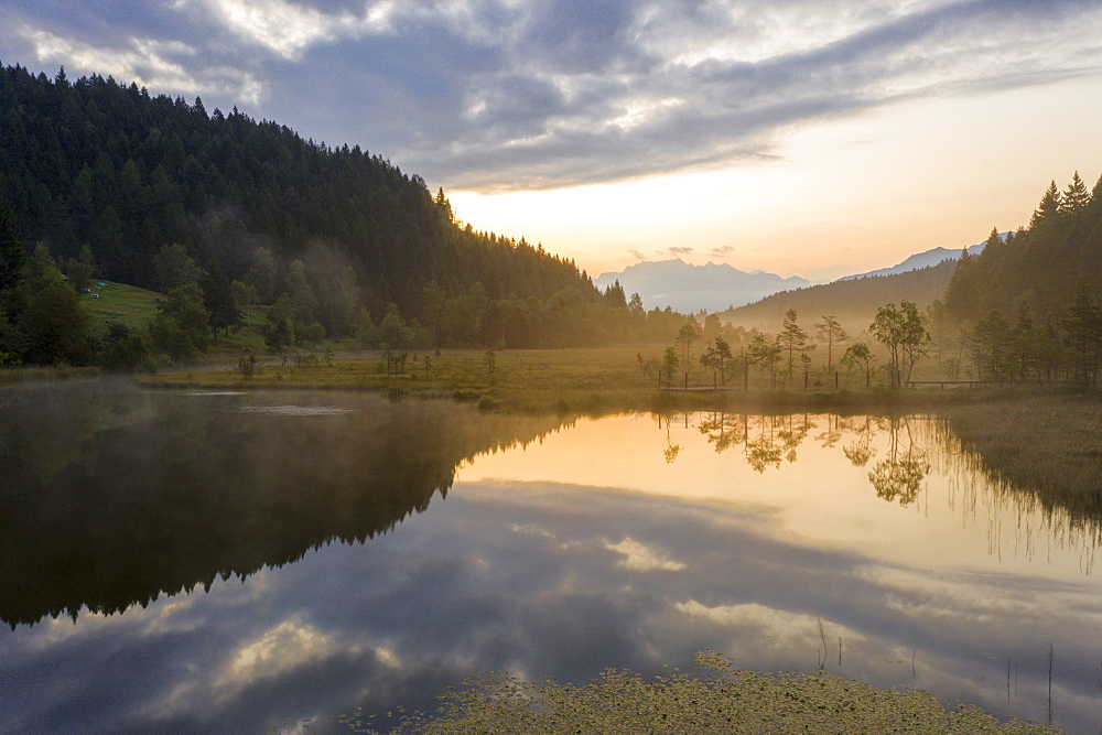 Aerial view of the misty sunrise over swamp of Pian di Gembro Nature Reserve, Aprica, Sondrio, Valtellina, Lombardy, Italy, Europe