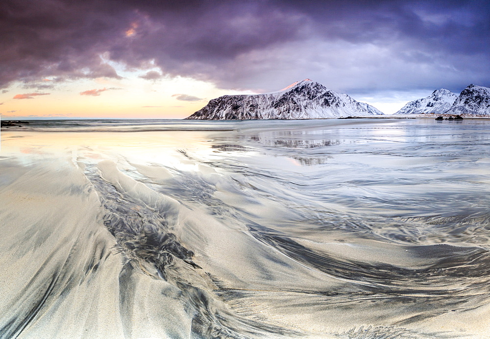 Sunset on the surreal Skagsanden beach surrounded by snow covered mountains, Flakstad, Lofoten Islands, Arctic, Norway, Scandinavia, Europe