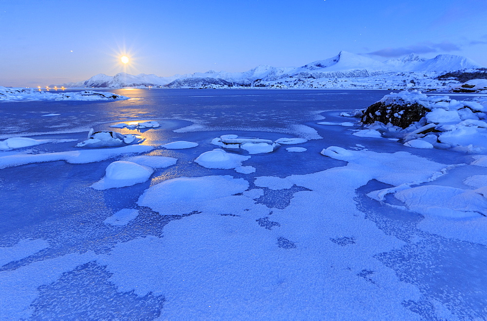 Reflections of full moon in the frozen sea, Lyngedal, Lofoten Islands, Arctic, Norway, Scandinavia, Europe